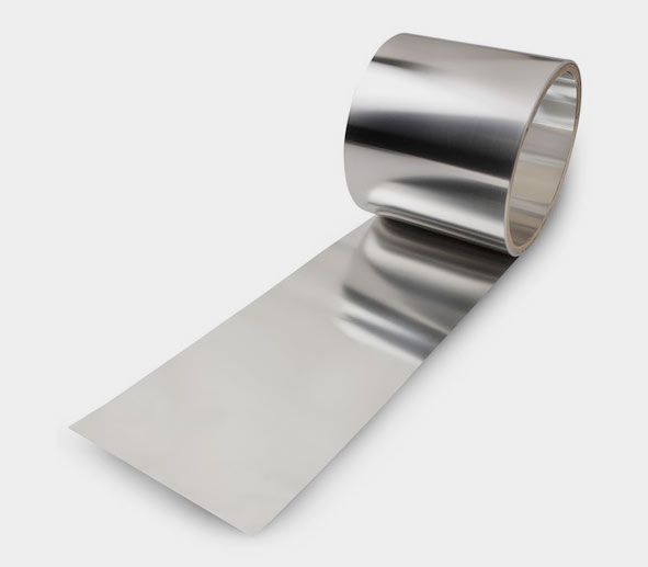 Shiny stainless steel foil roll partially unrolled on a flat surface